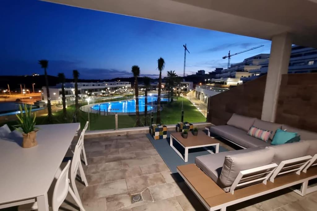 eine Terrasse mit einem Sofa und einem Pool in der Nacht in der Unterkunft Casa cariño in Alicante