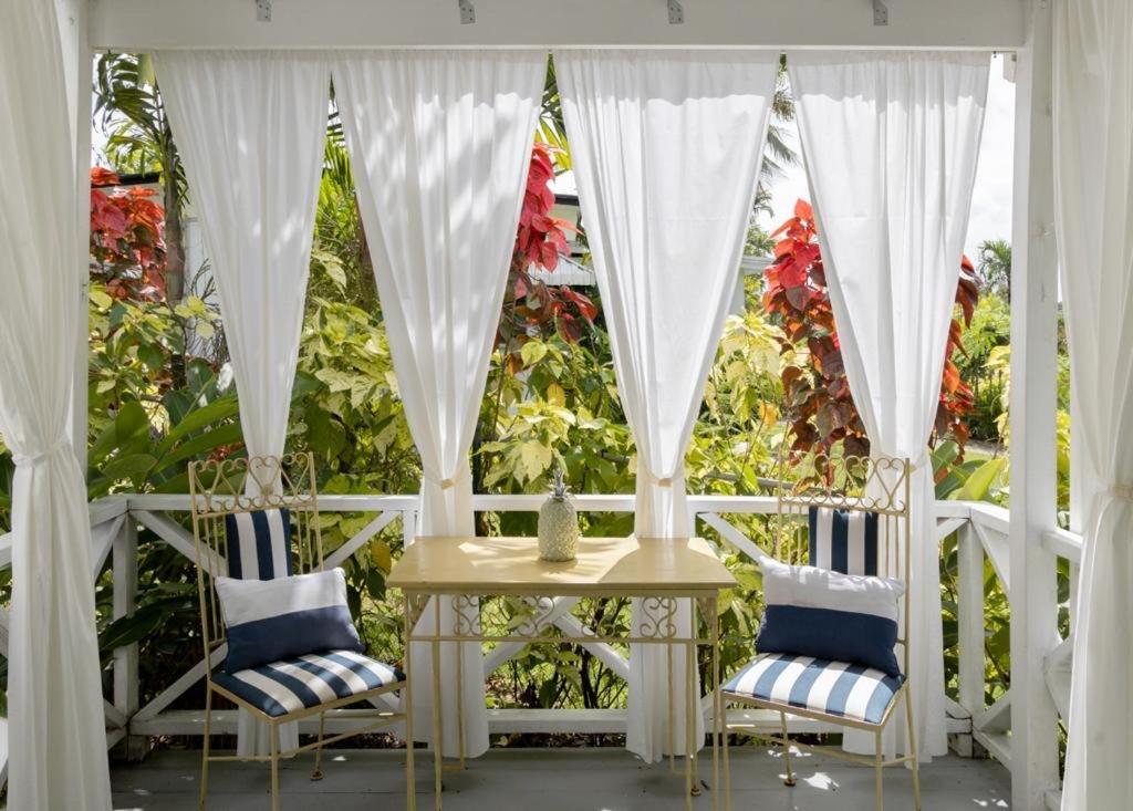 a porch with two chairs and a table and a window at Villa 46 in Saint James