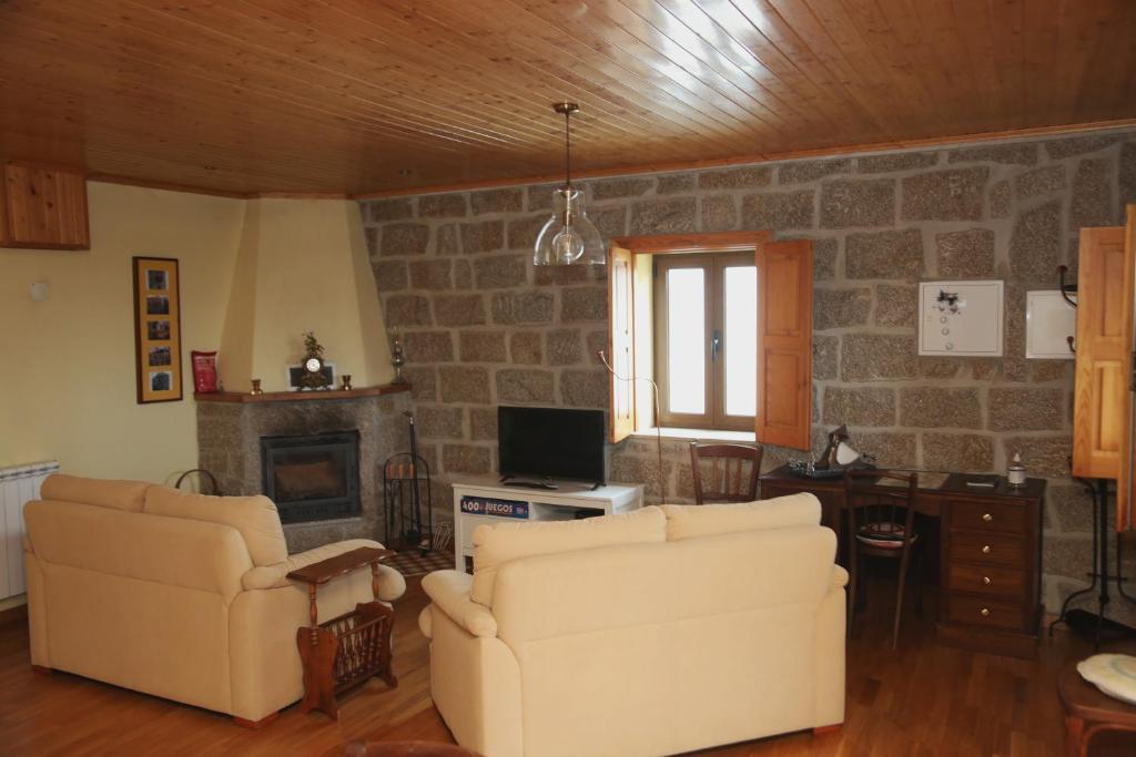 a living room with two chairs and a fireplace at Casa d'Avó Serra da Estrela in Seia