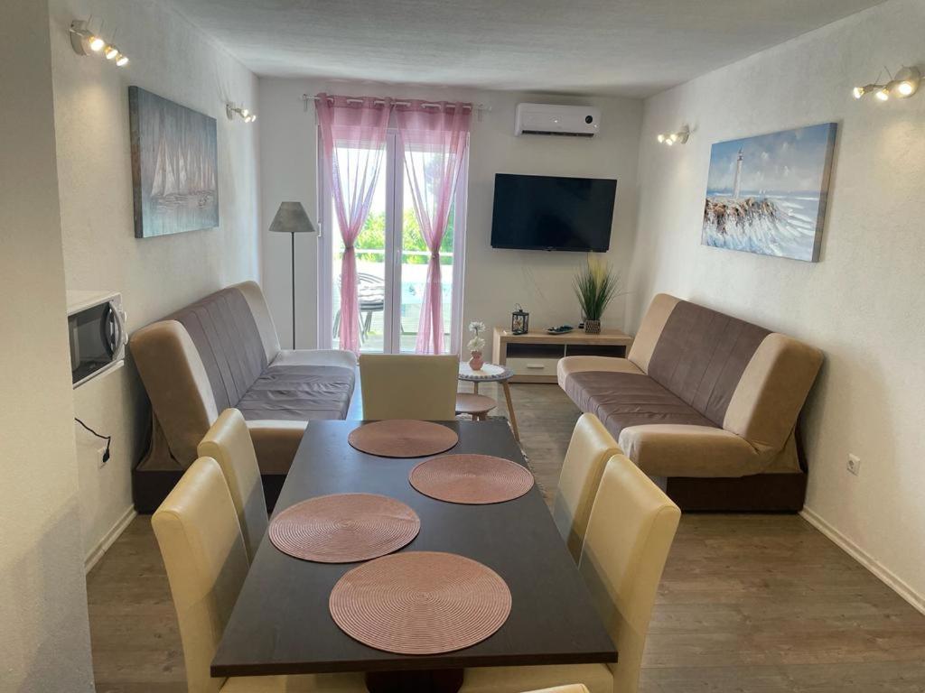 sala de estar con mesa y sofá en Nemira beach apartments, en Omiš