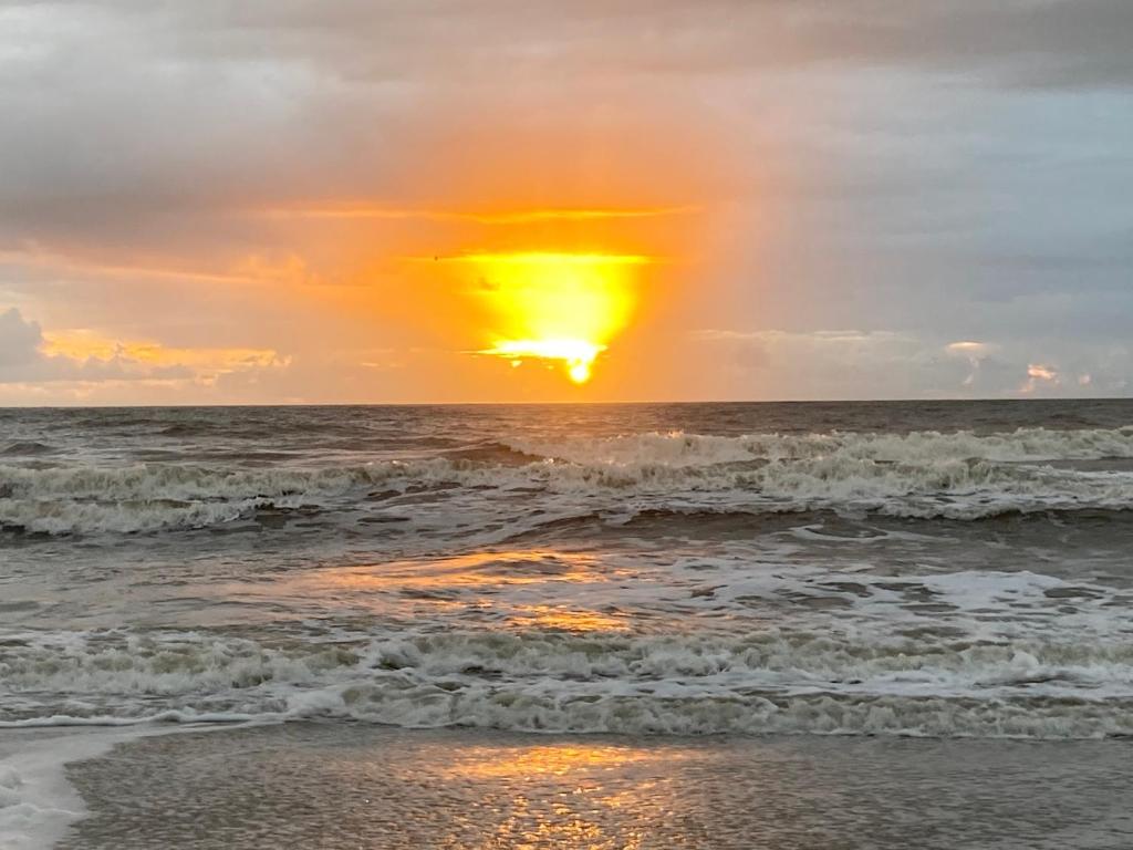 a sunset on the beach with the ocean at Hilton Head Resort in Hilton Head Island