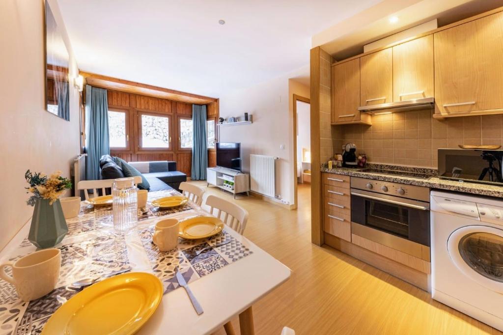 a kitchen and living room with a table with yellow chairs at S Valle de incles- Grandvalira free parking in Canillo