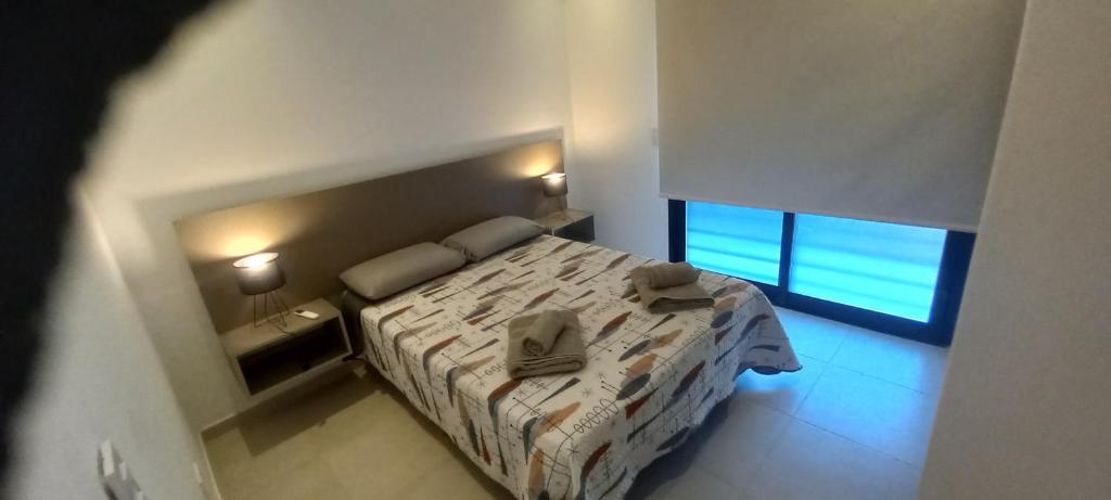 1 dormitorio pequeño con 1 cama y 2 ventanas en Colon Suites 2. Duplex a 18 minutos Aeropuerto Ezeiza en Monte Grande