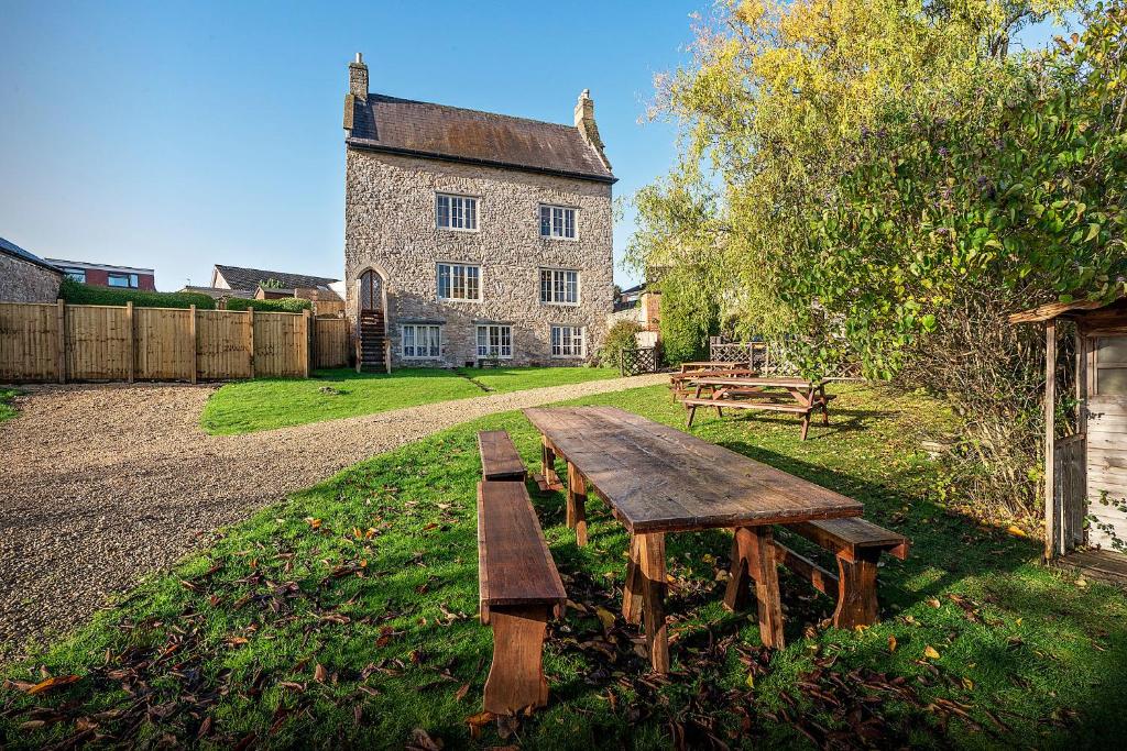 a wooden picnic table in front of a building at Medieval Manor in Caldicot