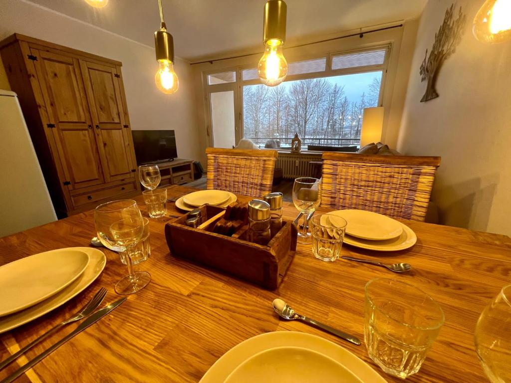 einen Holztisch mit Tellern und Weingläsern darauf in der Unterkunft Mountain Lodge in Sankt Andreasberg