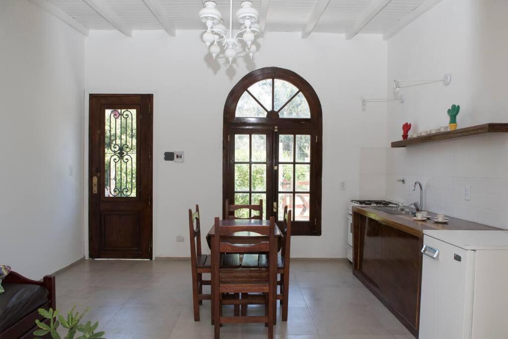eine Küche mit einem Tisch und Stühlen sowie einem Fenster in der Unterkunft Cabaña Nélida - Atlántida - Santa Clara del Mar in Santa Clara del Mar