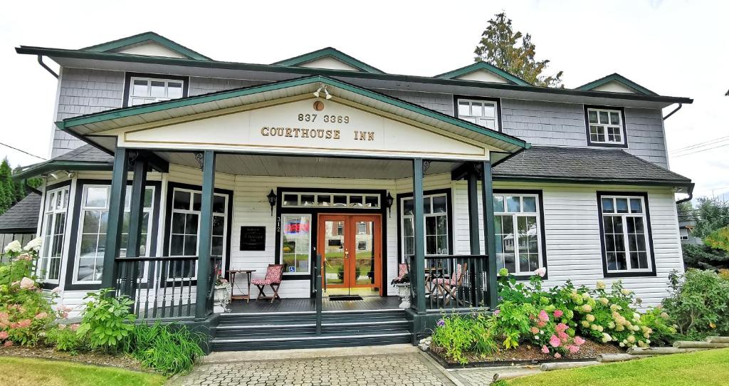 a white house with a christmas inn at Courthouse Inn Revelstoke in Revelstoke