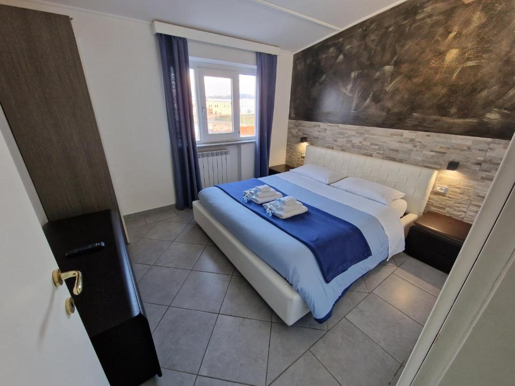 a bedroom with a bed with blue sheets and a painting on the wall at B&B FR House Affittacamere Colleferro in Colleferro