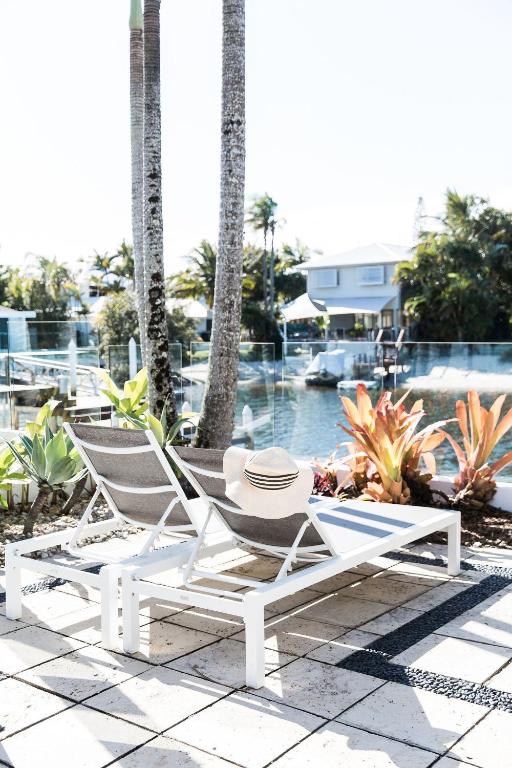 a pair of chairs and a table on a patio at The River House includes a private beach jetty and pool in Noosa Heads