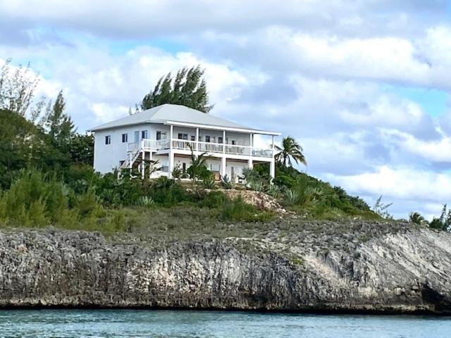a white house on an island in the water at Blue Love Point home in Gregory Town