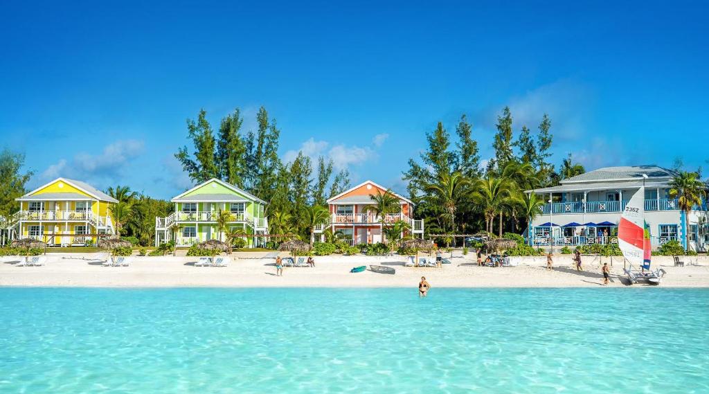 a beach with houses and people in the water at Cocodimama Resort Hotel Room in James Cistern