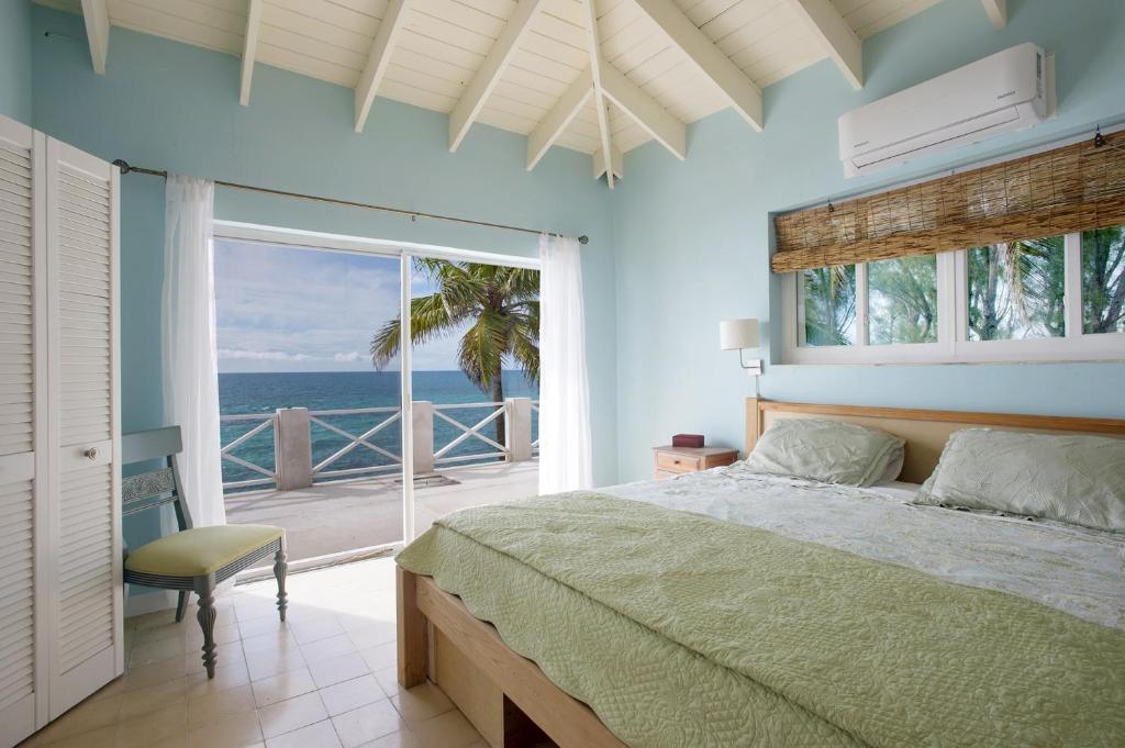 a bedroom with a bed and a view of the ocean at Gurgle and Whump cottage in Alice Town