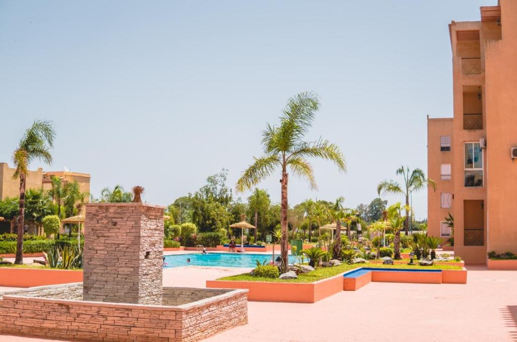 ośrodek z basenem i palmami w obiekcie Ricoflores PALM w mieście Benslimane