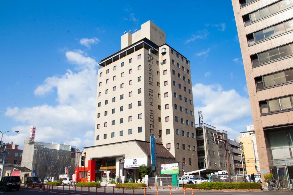um edifício branco com uma torre em cima em Green Rich Hotel Oita Miyakomachi em Oita