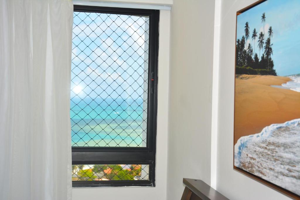 una ventana en una habitación con una valla en Apto1003 - Conde da Praia - Vista Mar, en Natal