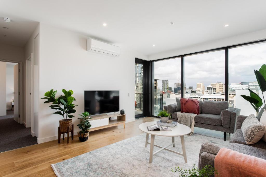 a living room with a couch and a tv at The East End Apartments by Urban Rest in Adelaide