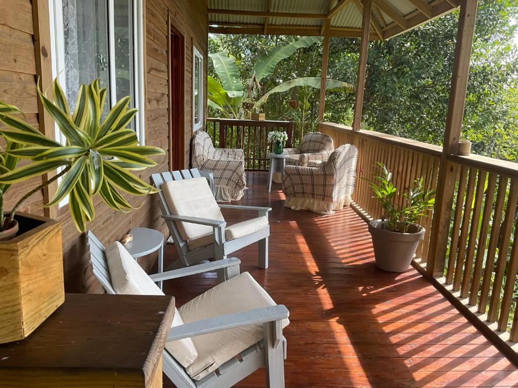 eine Veranda eines Hauses mit Stühlen und einem Tisch in der Unterkunft Pretty house Bastimentos Bocas del toro in Bastimentos