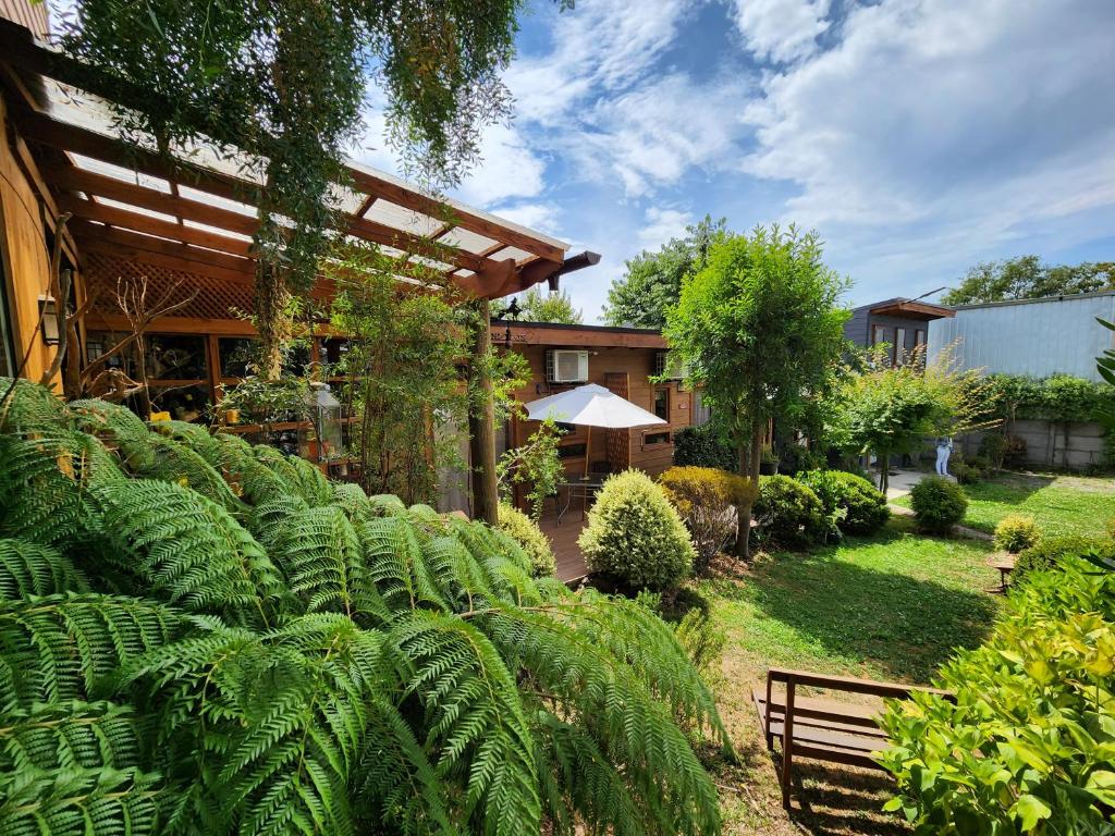 a garden with lush green plants and a building at Departamentos de turismo - Apart Hotel MiCasa in Futrono