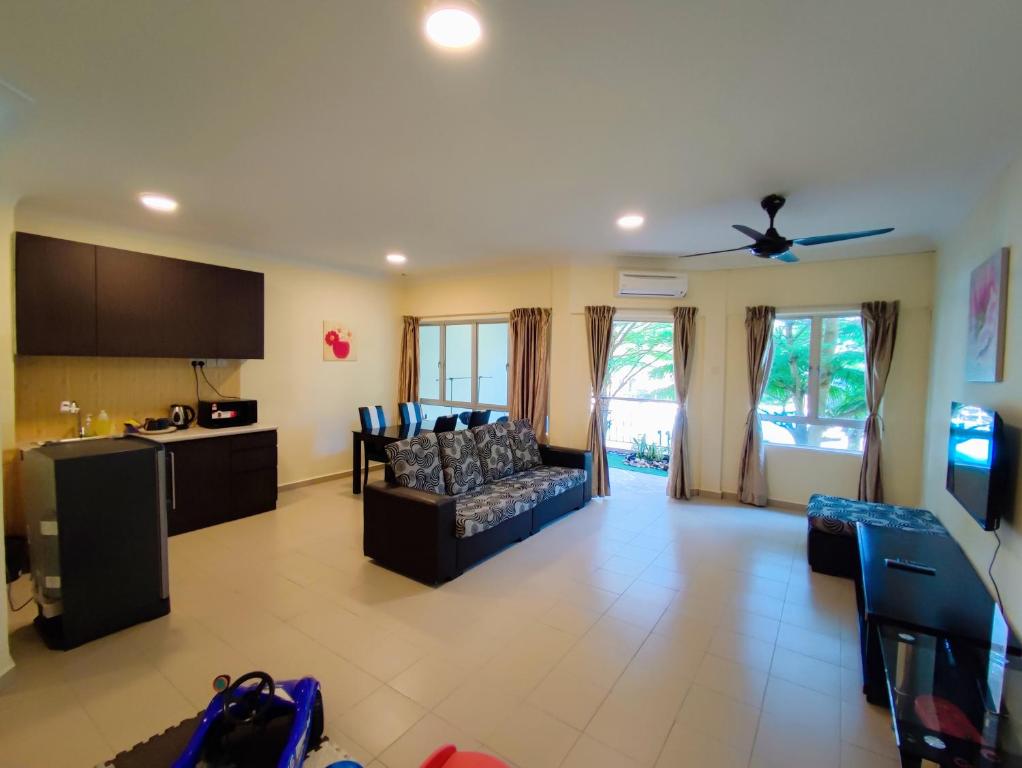 a living room with a couch and a kitchen at Le'Coco Homestay in Tiara Desaru Residence in Desaru