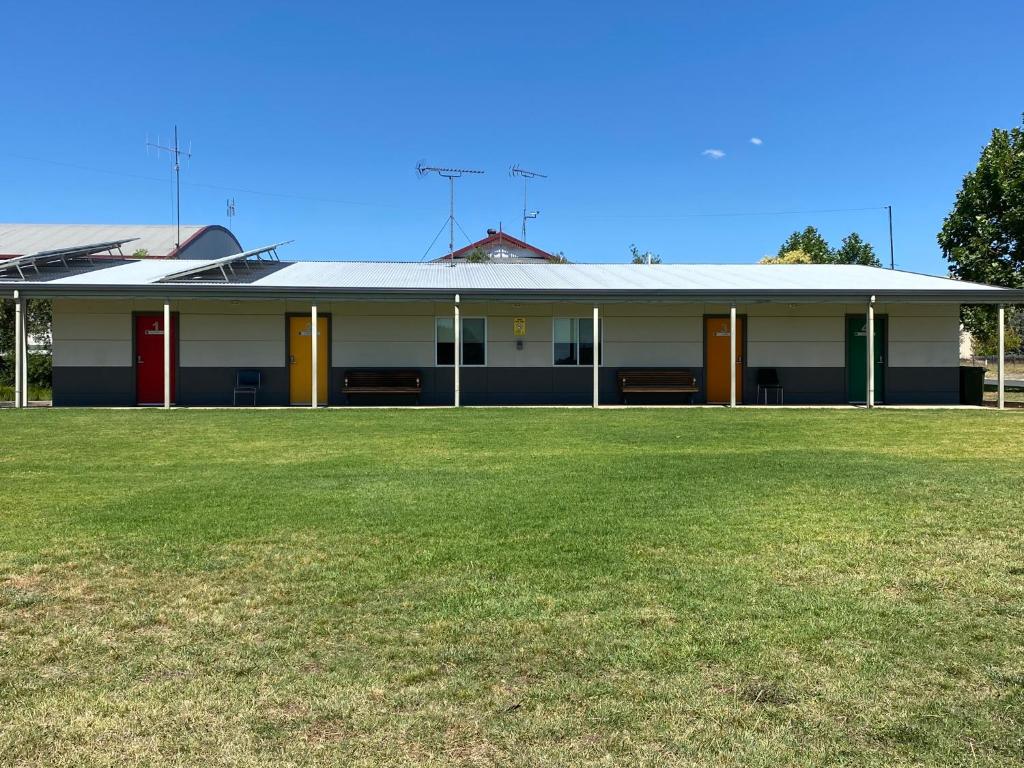 ein Gebäude mit einem grünen Feld davor in der Unterkunft Airfield Tourist Park Temora in Temora