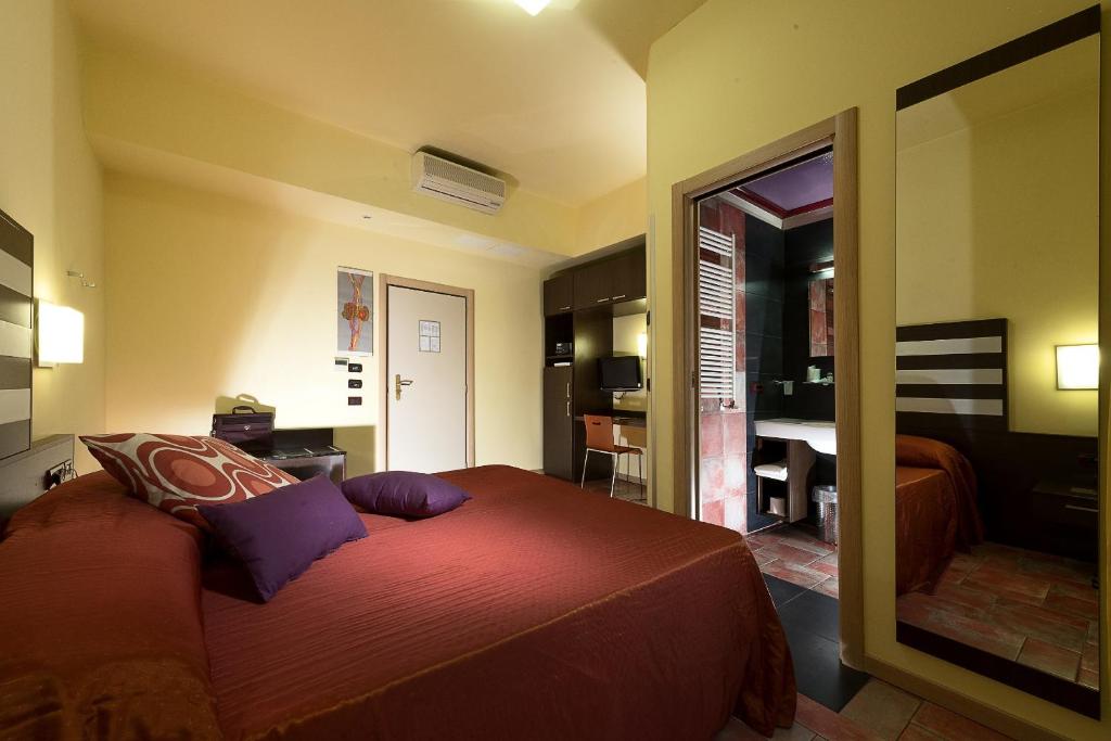a bedroom with a large bed and a mirror at Hotel La Pioppa in Bologna