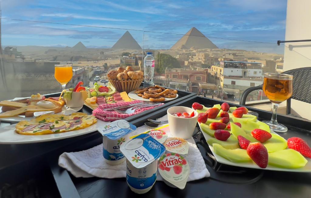 two plates of food on a table with a view of the pyramids at Sky Pyramids View in Cairo