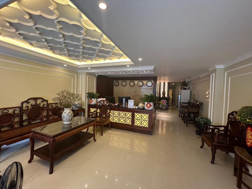 una hall con sedie, tavoli e soffitto di Apollo Airport Hotel ad Ho Chi Minh