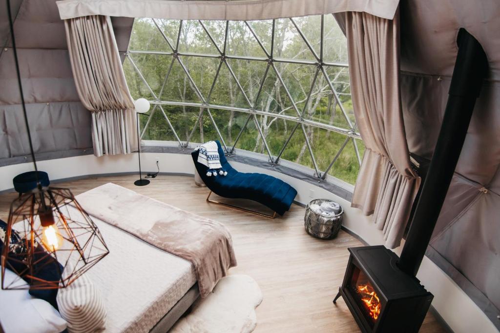 a room with a large window and a bed in a room at FlowEdge Riverside Getaway in Meaghers Grant