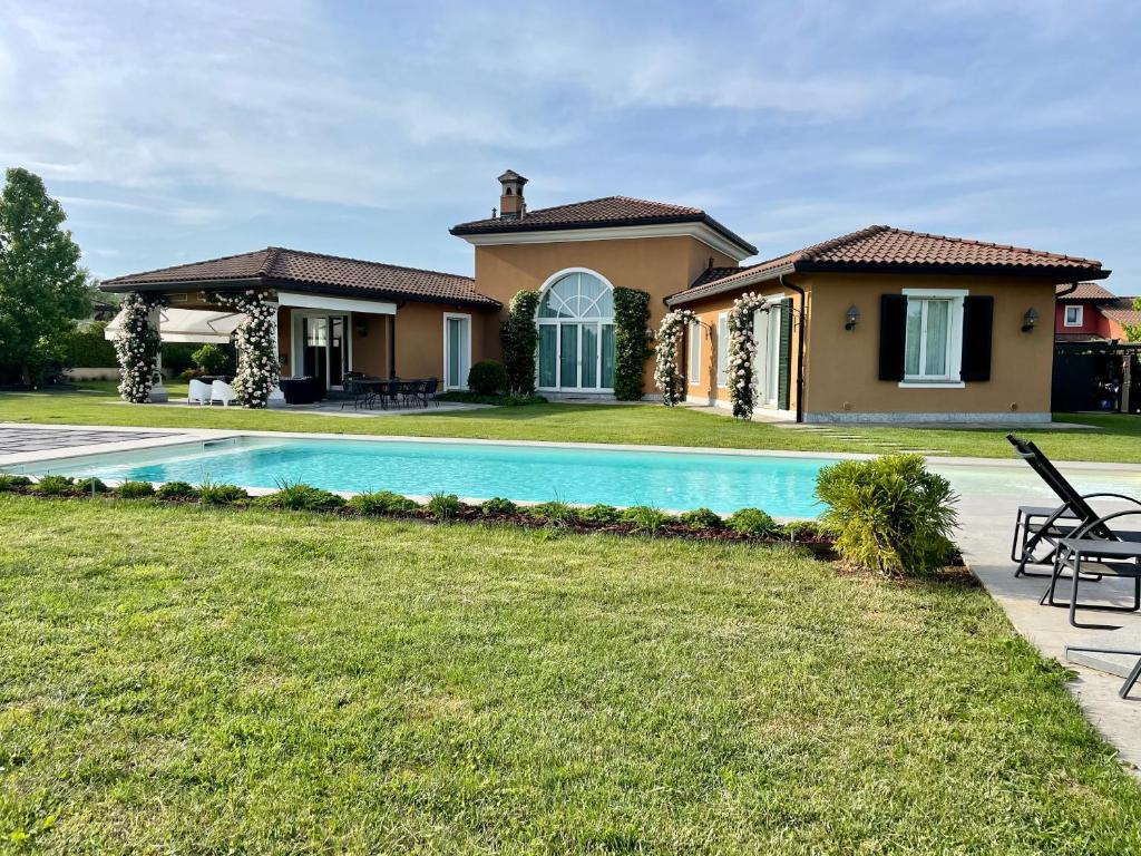 een huis met een zwembad in een tuin bij Front Row Golf Villa Bogogno in Bogogno