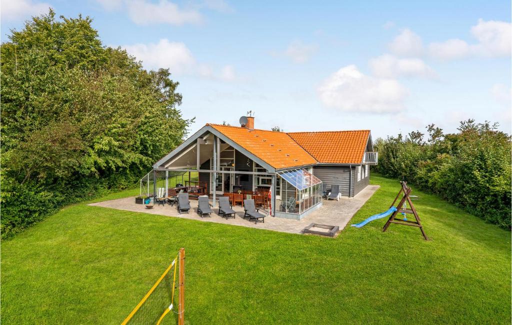 HelberskovにあるStunning Home In Hadsund With 5 Bedrooms, Sauna And Wifiのオレンジの屋根と遊び場のある家