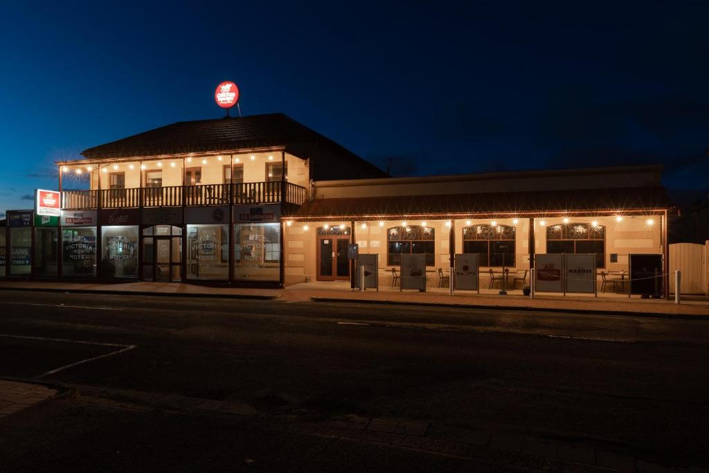 a building with a sign on top of it at night at The Victoria Hotel in Port MacDonnell