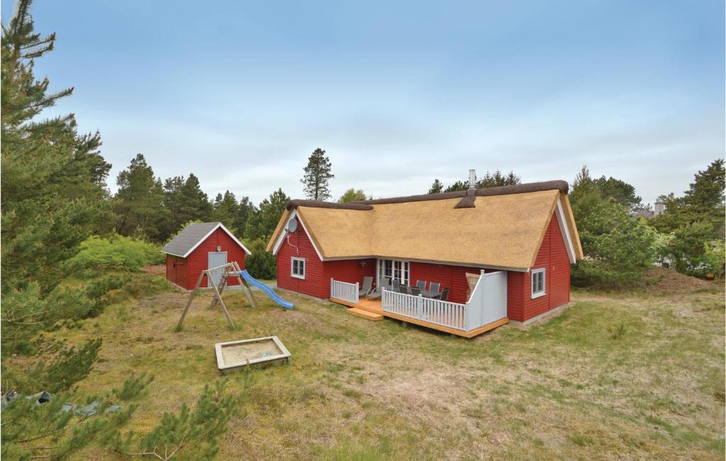 ein rotes Haus mit einem Spielplatz im Hof in der Unterkunft Lovely Home In Rm With Wifi in Rømø Kirkeby