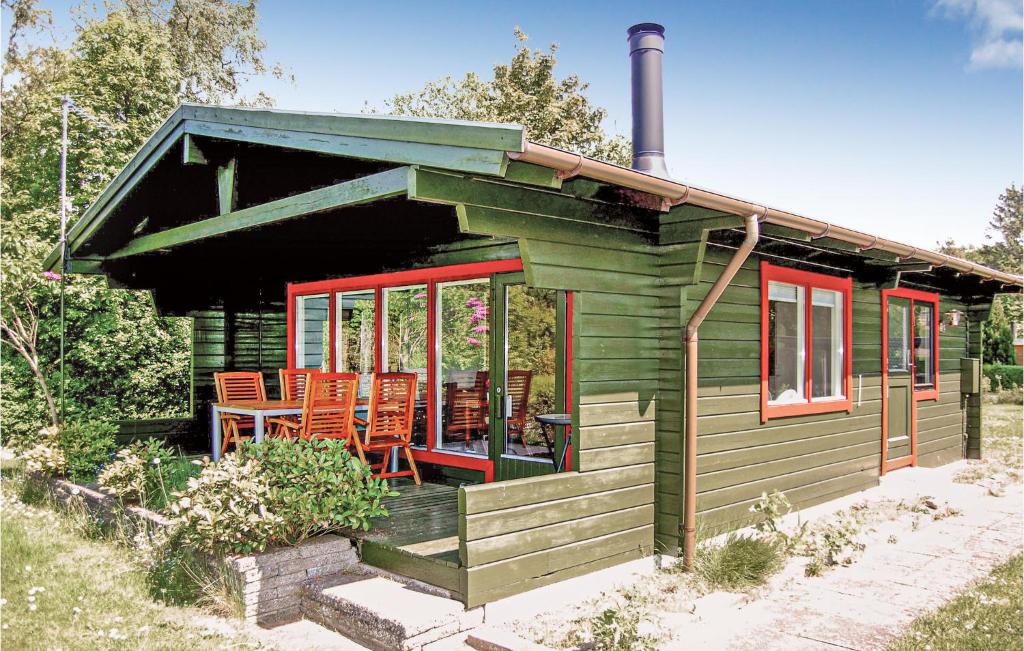 ボアディングボーにあるBeautiful Home In Vordingborg With 1 Bedrooms And Wifiの小さな緑のキャビン(オレンジ色の椅子付)