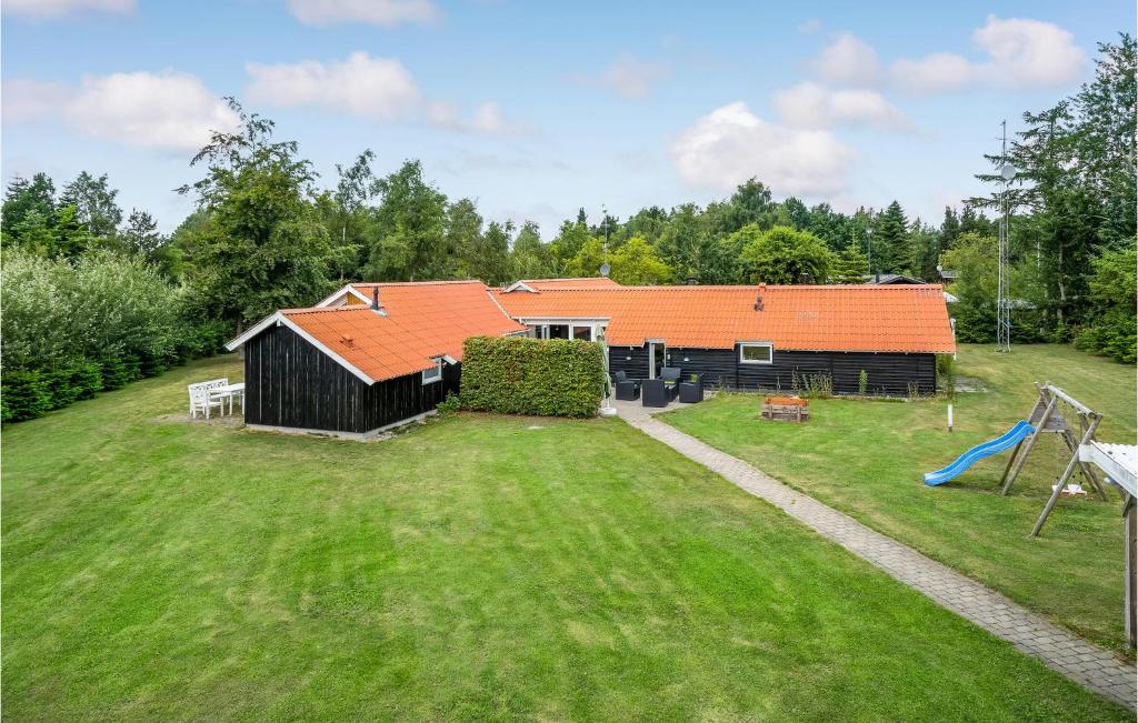 eine Luftaufnahme eines Hauses mit einem Spielplatz in der Unterkunft Cozy Home In Væggerløse With Sauna in Bøtø By