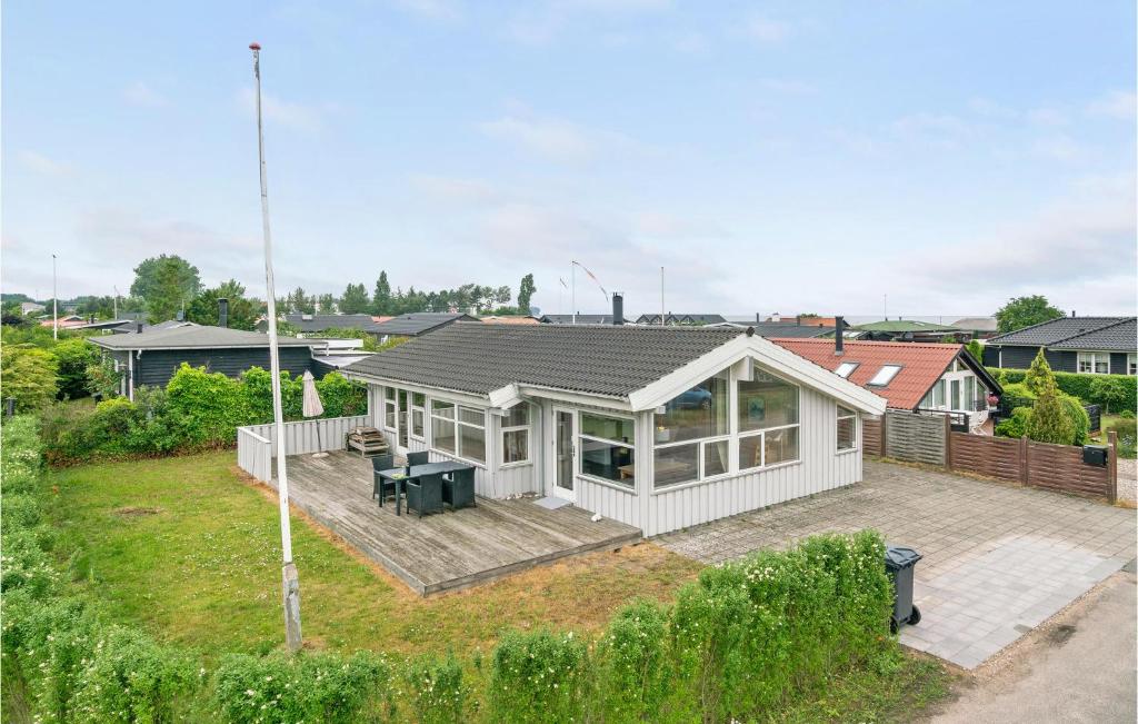 uma casa branca com um deque e um quintal em Birkely em Nyborg