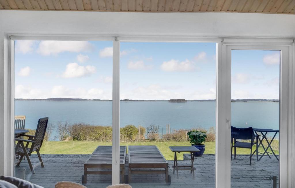 a screened in porch with a view of the water at 2 Bedroom Amazing Home In Faaborg in Faaborg