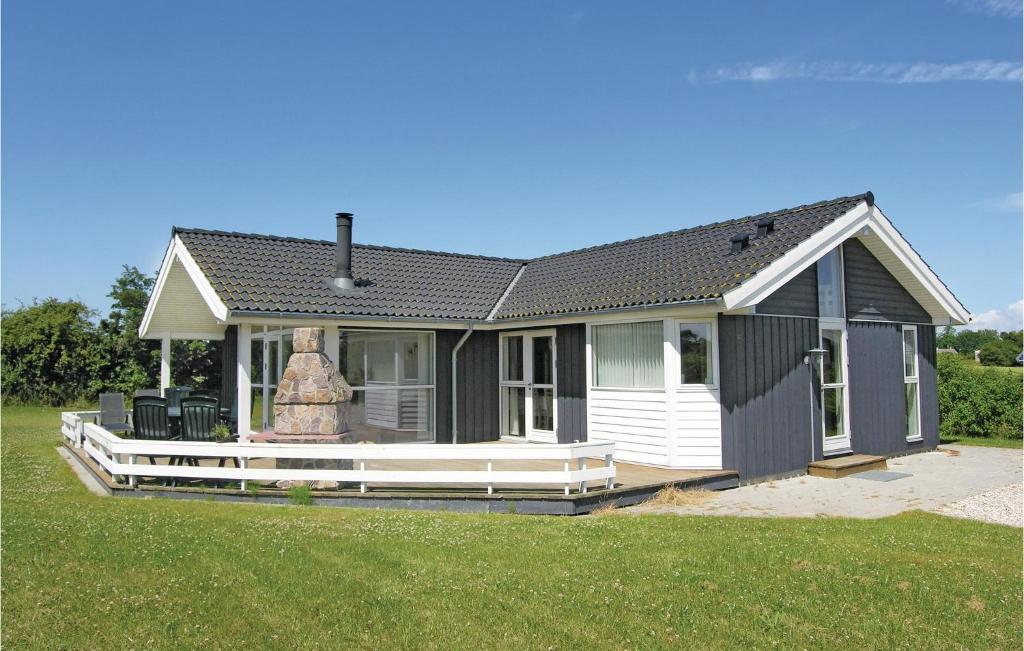 a small black and white house with a porch at Holiday Home Følfodvænget in Humble