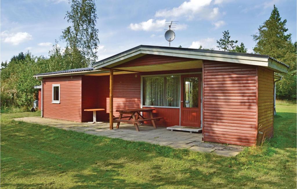 uma pequena cabana de madeira com uma mesa de piquenique num campo em Stunning Home In Herning With Kitchen em Kølkær