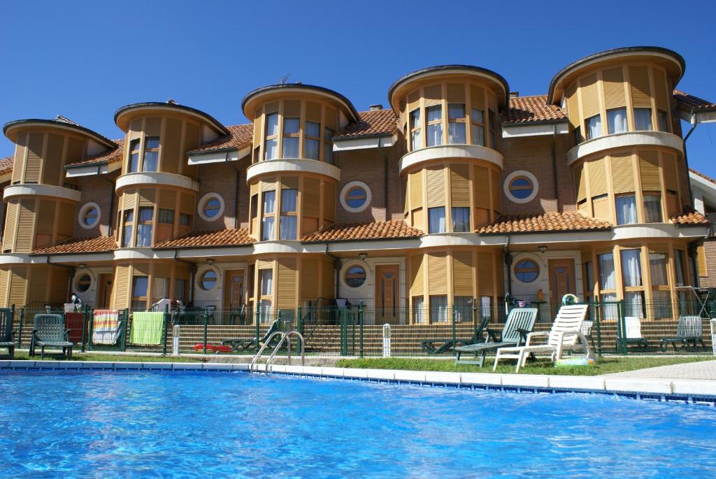 a large building with a pool in front of it at Apartamentos Quinto Sueño in Noja