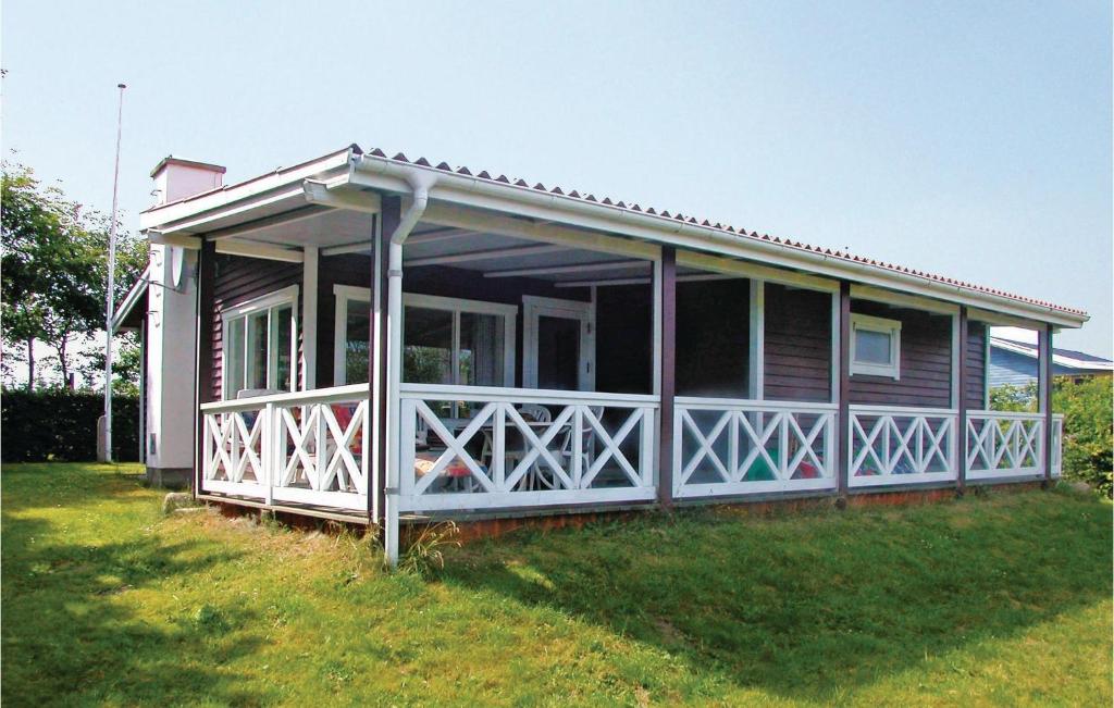 een klein huis met een veranda op een grasveld bij Awesome Home In Hadsund With Sauna in Haslevgårde