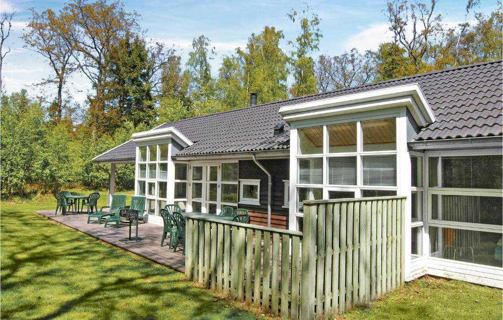 a white house with a fence and a patio at Rubinsøen Skovhuse in Hasle