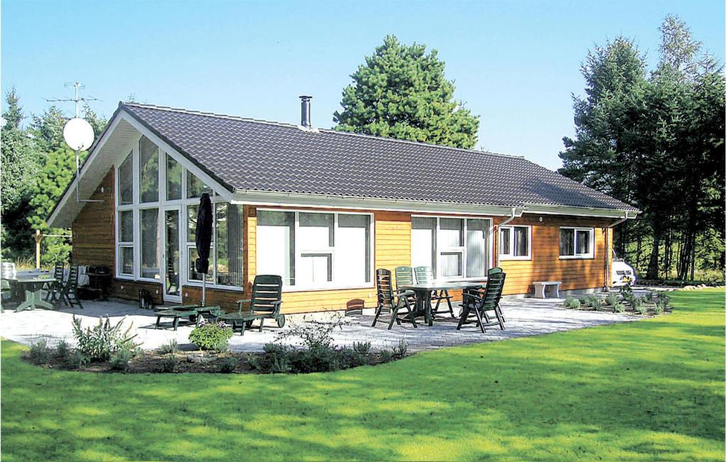 HelberskovにあるAmazing Home In Hadsund With 4 Bedrooms, Sauna And Wifiの庭にテーブルと椅子が備わるログキャビン