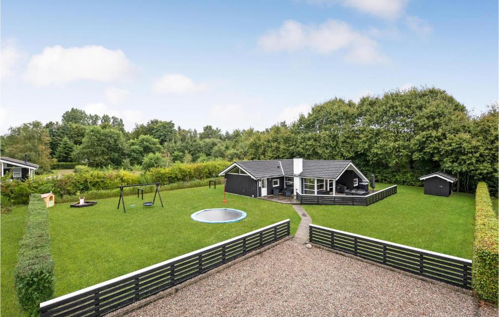 un ampio cortile con parco giochi e una casa di Holiday Home Østmarken Toftlund Ix ad Arrild