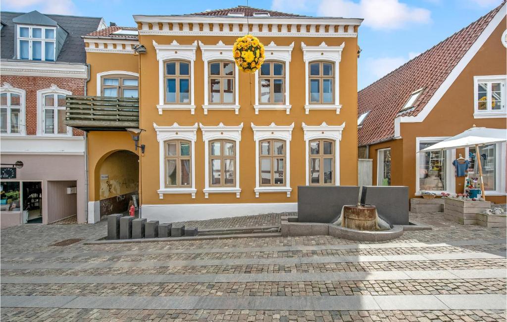 un gran edificio amarillo con un patio delante de él en Beautiful Apartment In Aabenraa With House A Panoramic View en Åbenrå