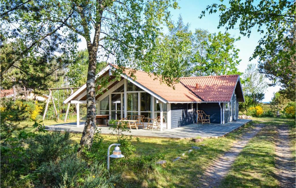 FjellerupにあるNice Home In Glesborg With 4 Bedrooms, Sauna And Wifiのポーチとデッキ付きのコテージ