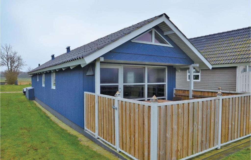 a blue house with a wooden fence at Amazing Home In Mesinge With House Sea View in Mesinge