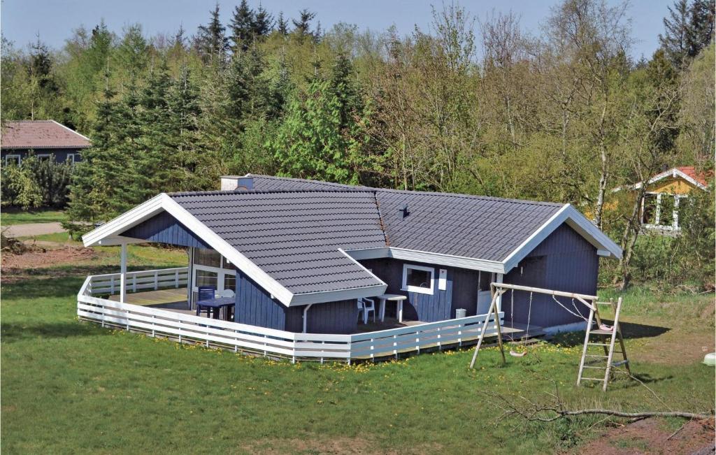 une maison bleue avec une terrasse couverte dans un champ dans l'établissement Awesome Home In Oksbl With Sauna, à Ovtrup