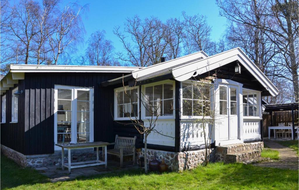 een klein huis met een bankje ervoor bij Stunning Home In Grsted With Wifi in Græsted