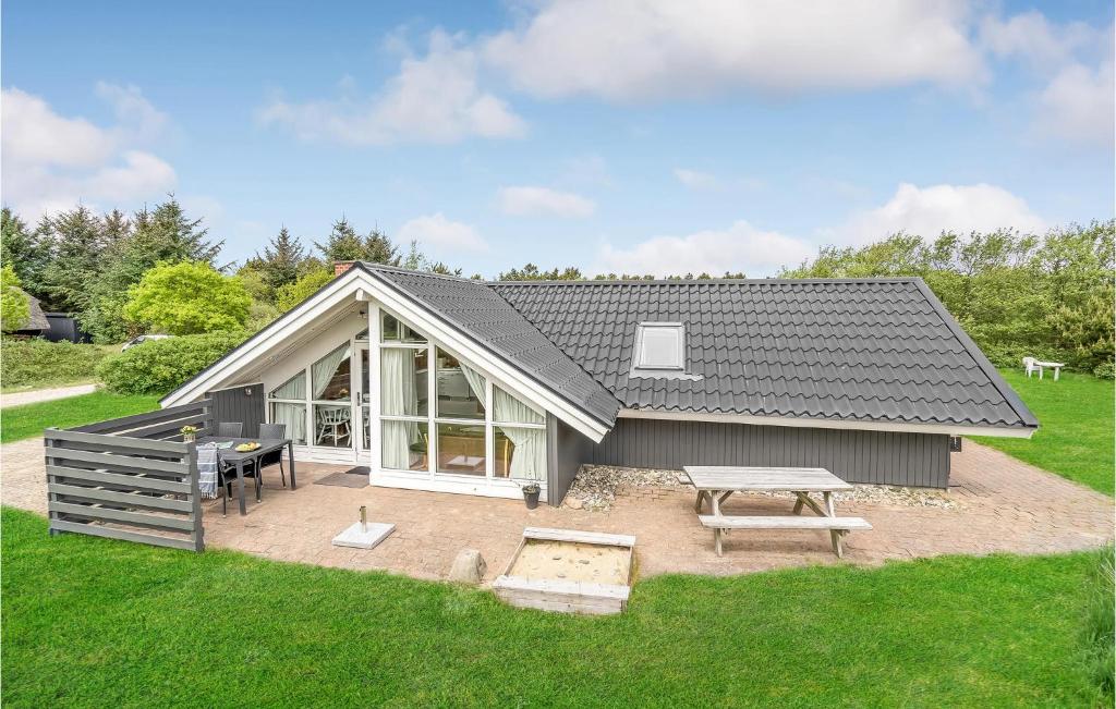 Casa pequeña con mesa de picnic y patio en Pet Friendly Home In Hvide Sande With Sauna, en Bjerregård