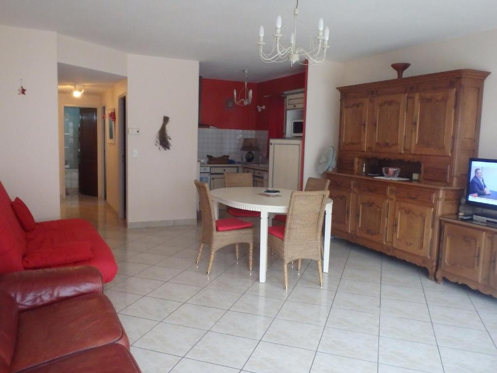 eine Küche und ein Wohnzimmer mit einem Tisch und Stühlen in der Unterkunft Le Moulin des Prés in Vesoul